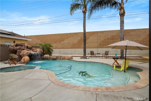 view of swimming pool featuring a patio, a fenced backyard, and a pool with connected hot tub