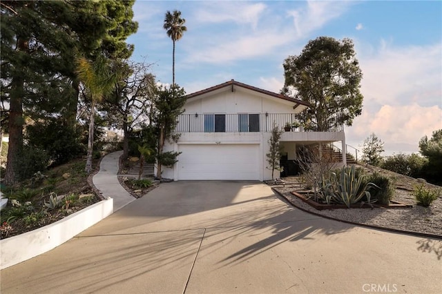 view of front of house featuring a garage, concrete driveway, and stairway