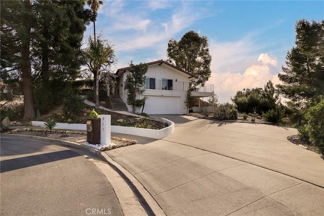 view of front facade with a garage, concrete driveway, and stairs