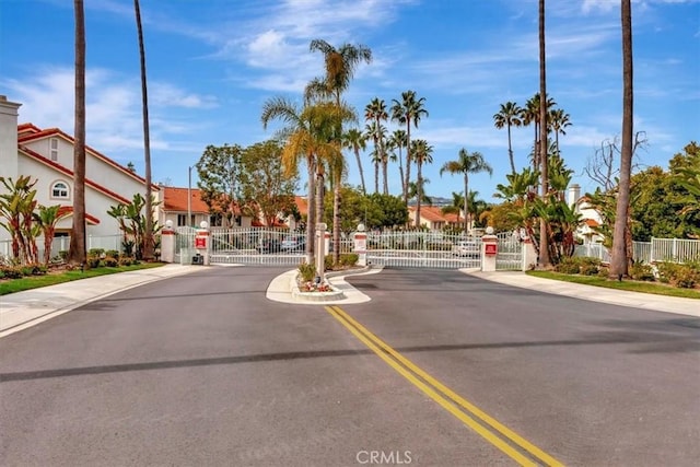 view of street featuring sidewalks, a gate, a gated entry, and curbs