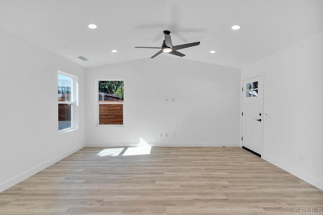 spare room with light wood-type flooring, lofted ceiling, and ceiling fan