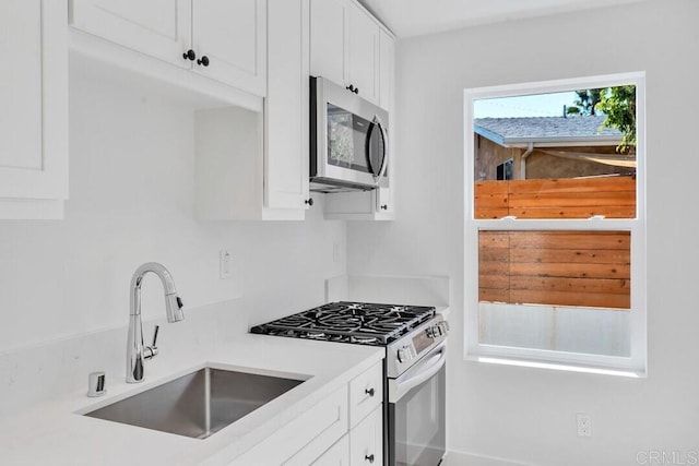 kitchen featuring sink, appliances with stainless steel finishes, and white cabinets