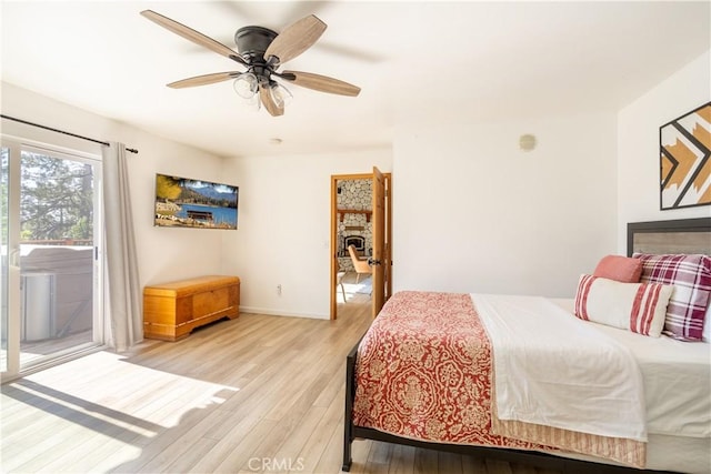 bedroom featuring light hardwood / wood-style flooring, ceiling fan, and access to outside