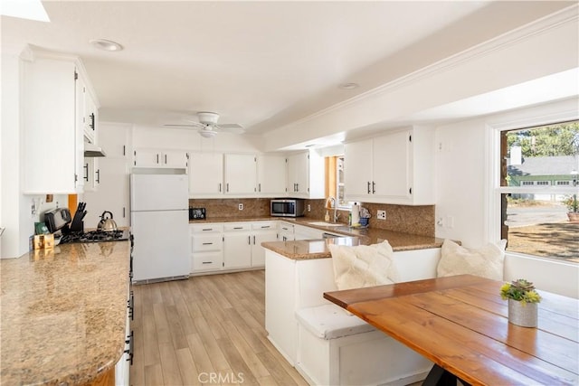 kitchen with white fridge, sink, tasteful backsplash, and white cabinets