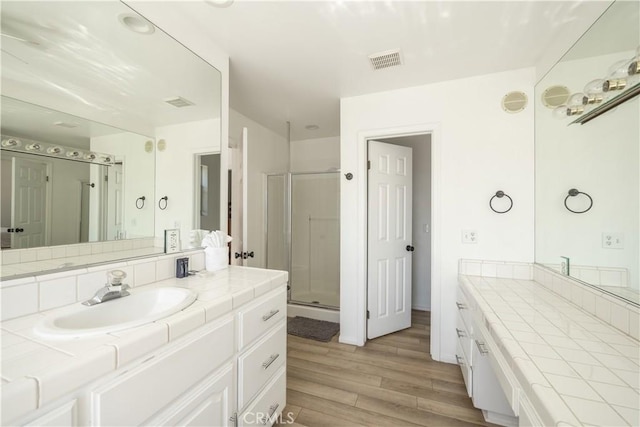 bathroom with vanity, an enclosed shower, and wood-type flooring