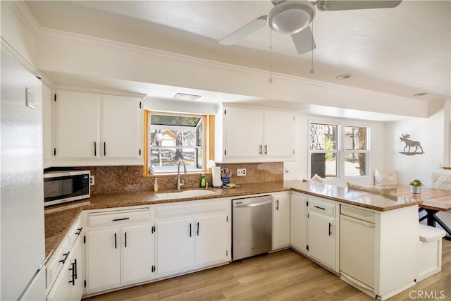 188 S Finch Dr, Big Bear Lake, CA 92315 - kitchen with stainless steel appliances, a sink, a peninsula, backsplash, and ornamental molding