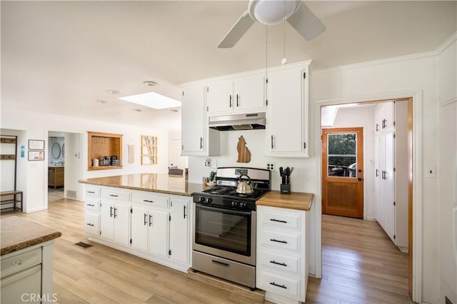 kitchen featuring white cabinetry, light wood-type flooring, stainless steel range with gas stovetop, and light stone countertops