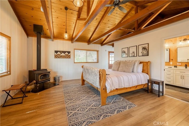 188 S Finch Dr, Big Bear Lake, CA 92315 - bedroom featuring wood ceiling, light wood-type flooring, a wood stove, connected bathroom, and wooden walls