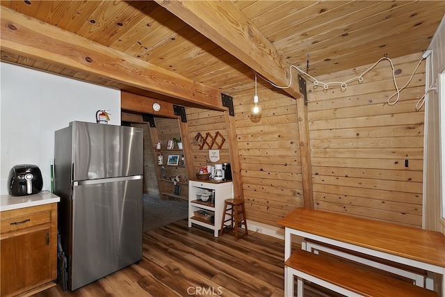 kitchen featuring wood ceiling, wood walls, stainless steel fridge, beamed ceiling, and dark hardwood / wood-style floors