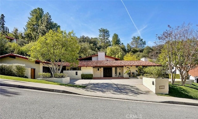 mediterranean / spanish home featuring a tiled roof and stucco siding