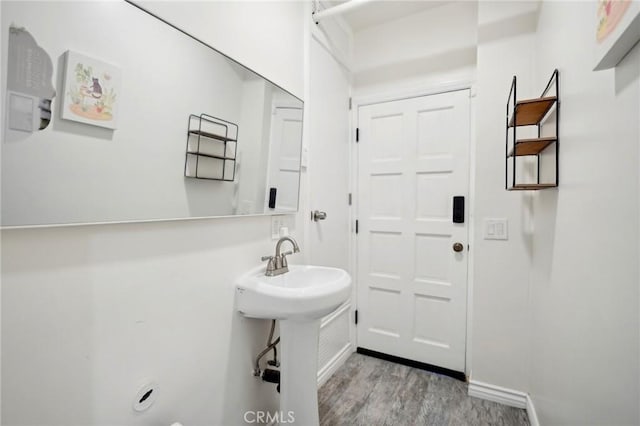 bathroom with a sink, wood finished floors, and baseboards