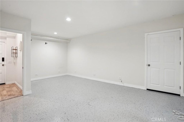 unfurnished room with recessed lighting, baseboards, and speckled floor