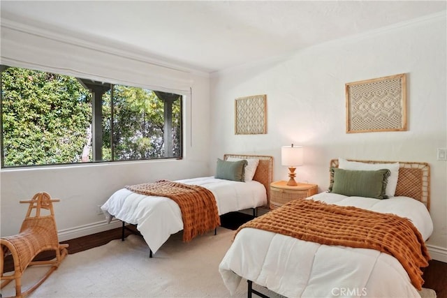 bedroom featuring baseboards, ornamental molding, and wood finished floors