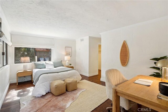 bedroom with baseboards, visible vents, ornamental molding, dark wood-type flooring, and a textured ceiling