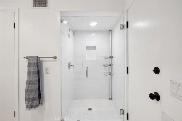 full bathroom featuring a shower stall and visible vents