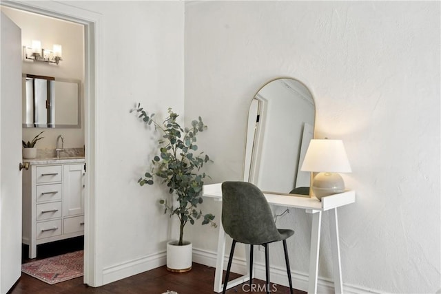 office space featuring dark wood-style floors, baseboards, and a sink