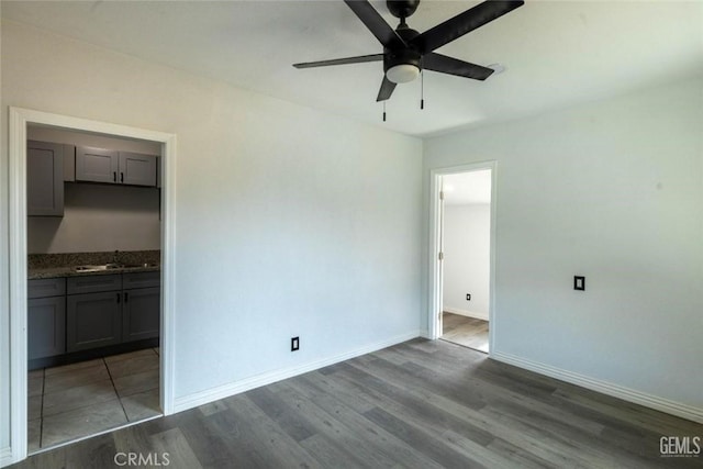 unfurnished bedroom with ensuite bath, dark hardwood / wood-style flooring, and sink