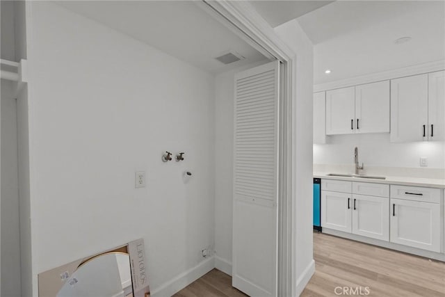 laundry room with sink and light wood-type flooring