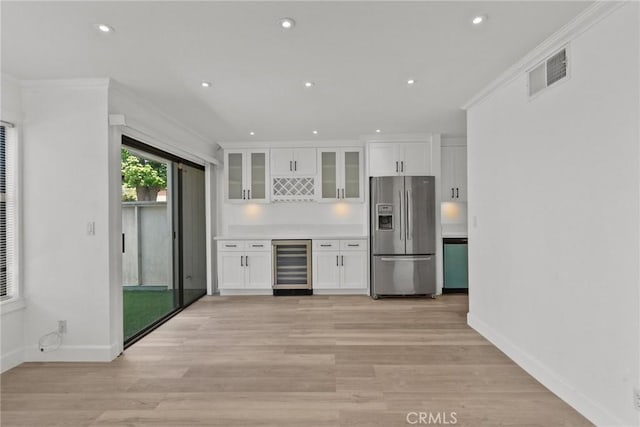 kitchen with light hardwood / wood-style flooring, beverage cooler, stainless steel refrigerator with ice dispenser, white cabinetry, and crown molding