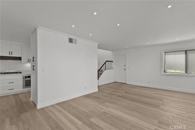 interior space featuring light wood-type flooring and ornamental molding