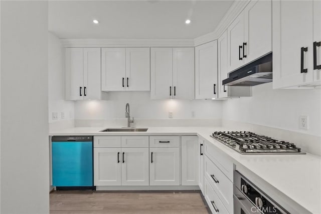 kitchen with white cabinets, light wood-type flooring, stainless steel appliances, and sink