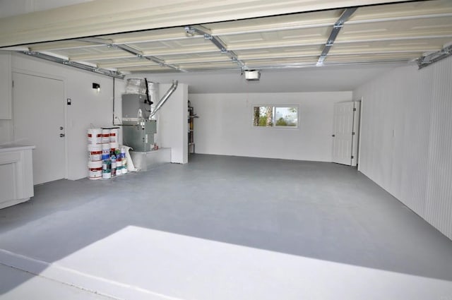 garage featuring a garage door opener and heating unit