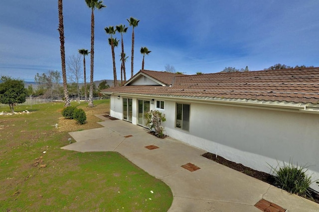 back of property featuring a patio and a lawn