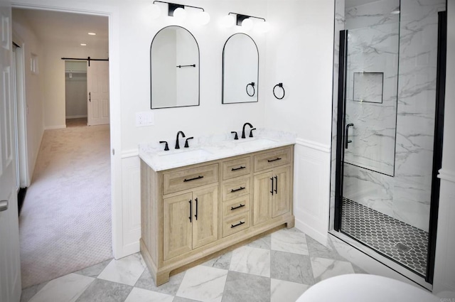 bathroom featuring a shower with door and vanity