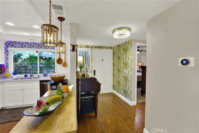 kitchen featuring sink, white cabinetry, dark hardwood / wood-style floors, ceiling fan, and hanging light fixtures