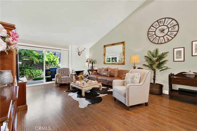 living room with hardwood / wood-style flooring, high vaulted ceiling, and a fireplace