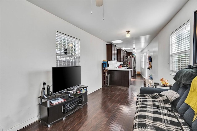 living room featuring ceiling fan, dark hardwood / wood-style floors, and a healthy amount of sunlight