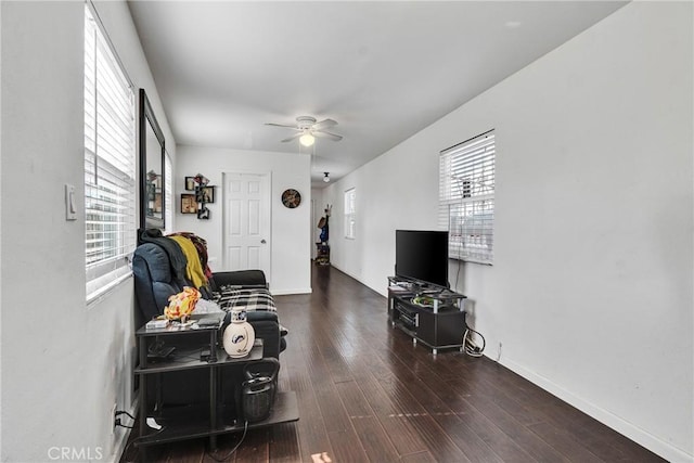 living room with a healthy amount of sunlight, dark wood-type flooring, and ceiling fan