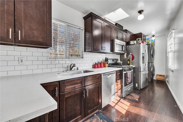 kitchen with dark hardwood / wood-style flooring, dark brown cabinetry, sink, appliances with stainless steel finishes, and decorative backsplash