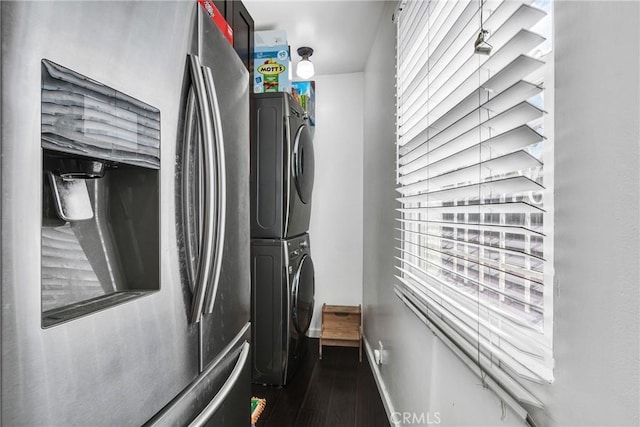 laundry room featuring stacked washer / drying machine and dark hardwood / wood-style floors