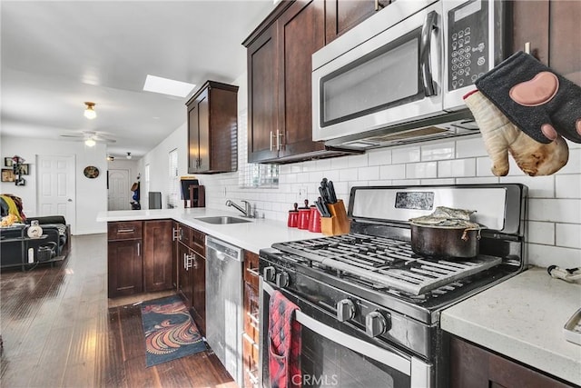 kitchen featuring sink, tasteful backsplash, ceiling fan, appliances with stainless steel finishes, and dark hardwood / wood-style floors