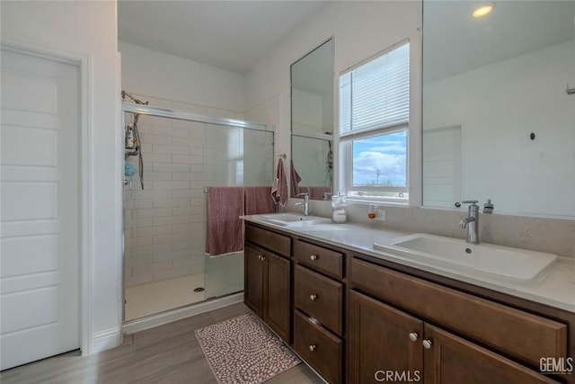 bathroom with vanity, wood-type flooring, and a shower with door