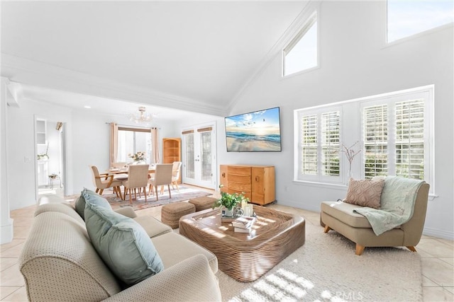 living area with a notable chandelier, high vaulted ceiling, light tile patterned flooring, and baseboards