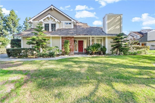 view of front of home featuring brick siding, a chimney, a front lawn, and stucco siding