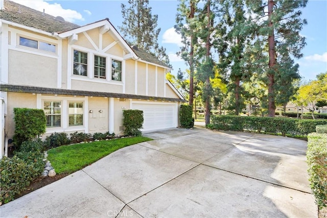 view of side of property with driveway, a garage, and stucco siding