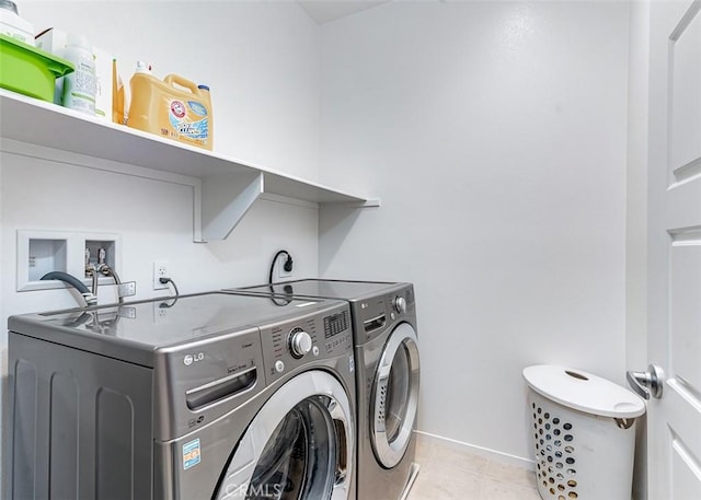 clothes washing area featuring separate washer and dryer and light tile patterned floors