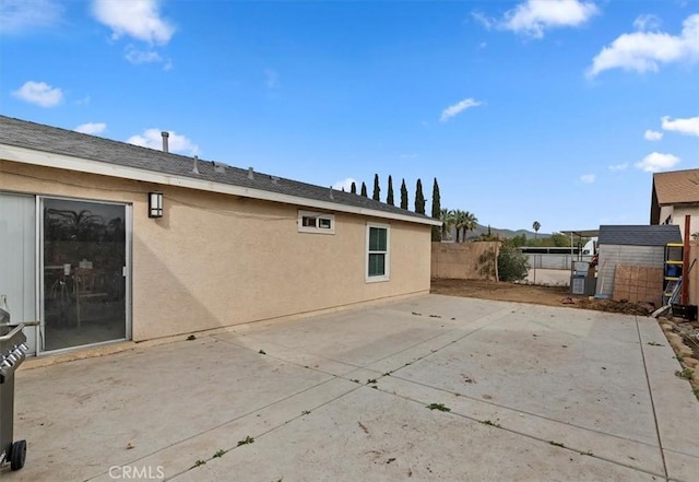 back of house featuring a patio and a storage shed