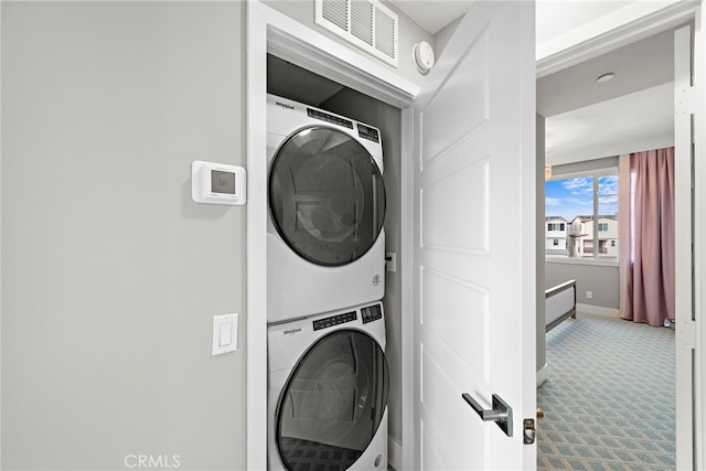 laundry room with stacked washer / dryer and carpet
