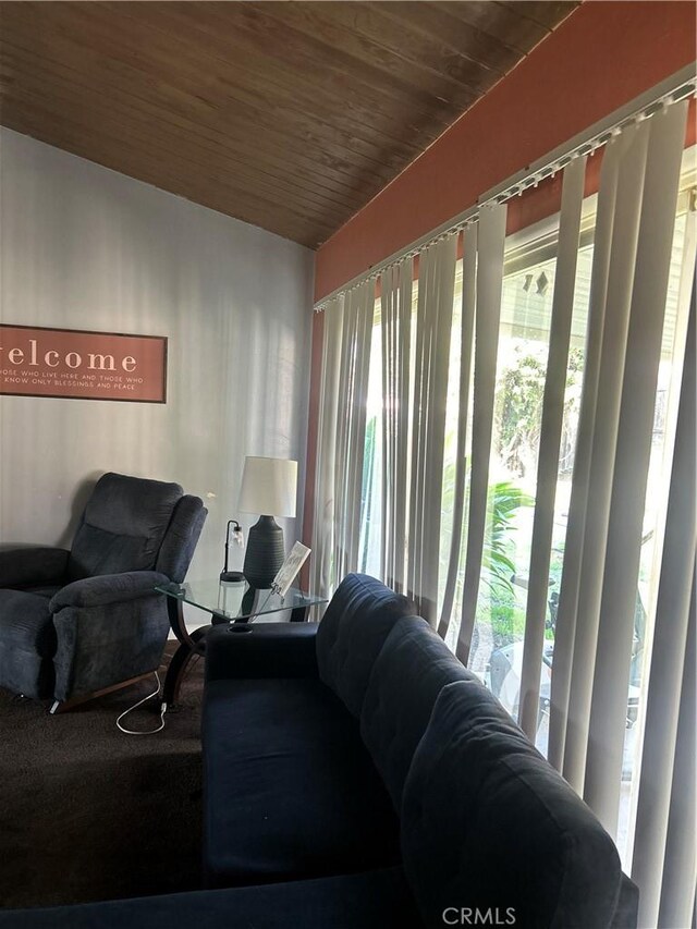 living room with a wealth of natural light, wooden ceiling, and vaulted ceiling