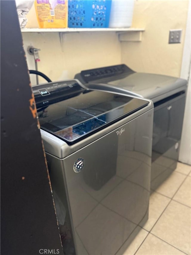 washroom with laundry area, light tile patterned floors, and independent washer and dryer