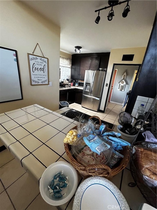 kitchen with light tile patterned floors, track lighting, and stainless steel refrigerator with ice dispenser