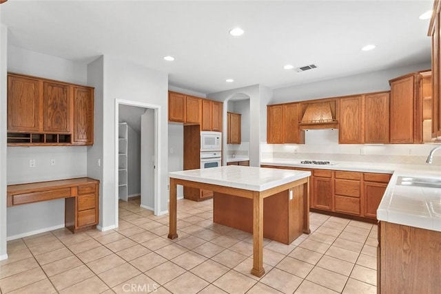 kitchen with tile countertops, visible vents, white appliances, and a sink