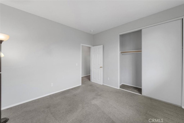 unfurnished bedroom with a closet, baseboards, and carpet
