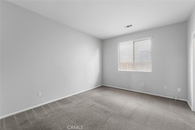 empty room featuring visible vents, baseboards, and carpet floors