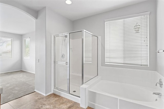 full bathroom featuring tile patterned flooring, a bath, and a stall shower