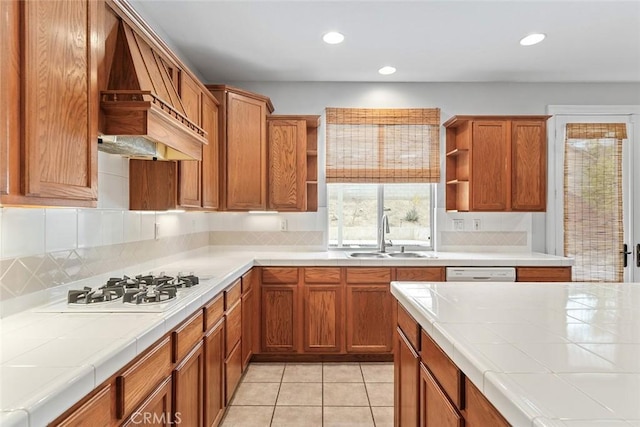 kitchen featuring tasteful backsplash, open shelves, a sink, white appliances, and tile counters